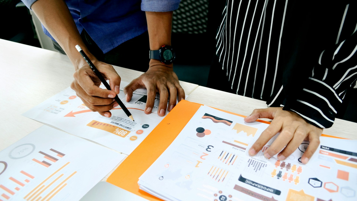 Closeup of two individual's hands on data reports.