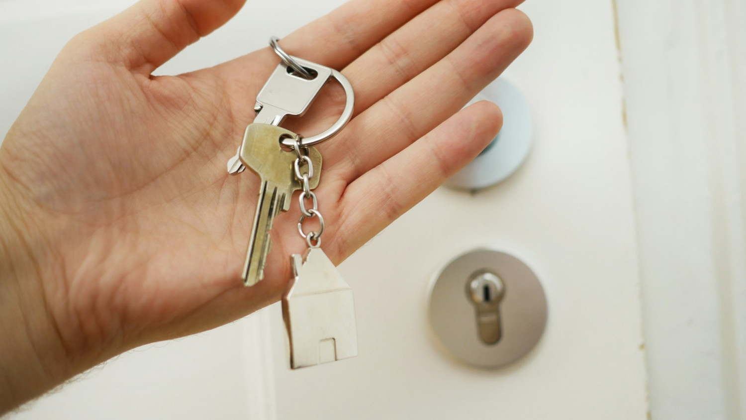 A hand holding house keys.