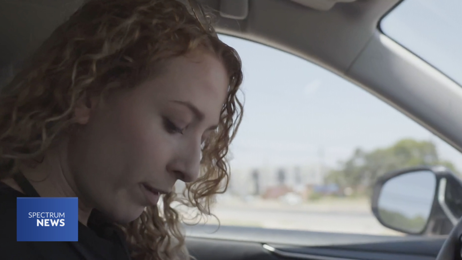 A woman sitting in her car