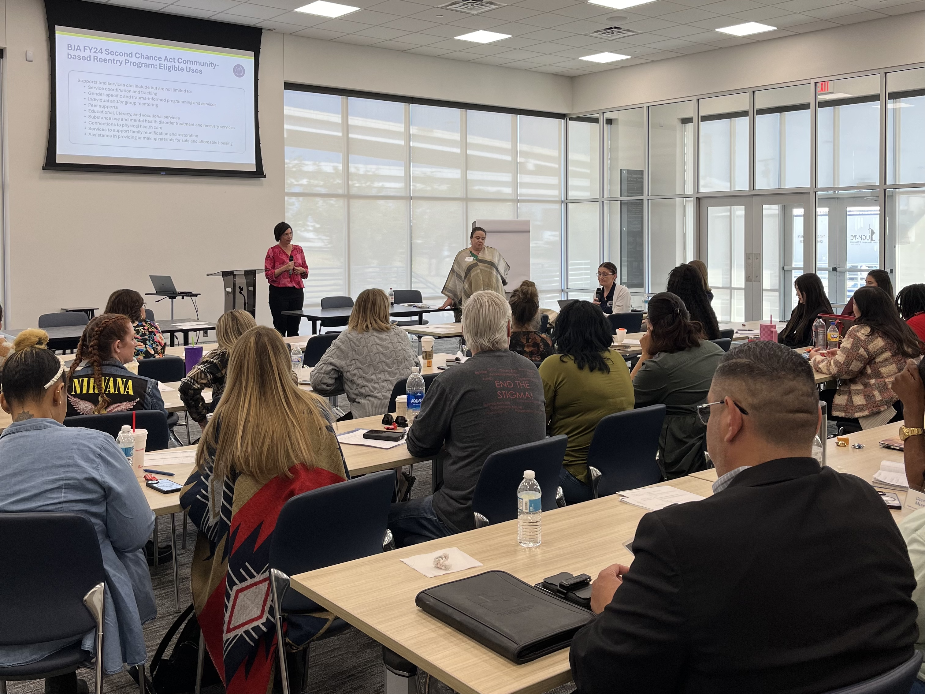 A group of people sitting in a conference room watching presenters during the Reentry Learning Collaborative's Kick Off Meeting in October 2024.