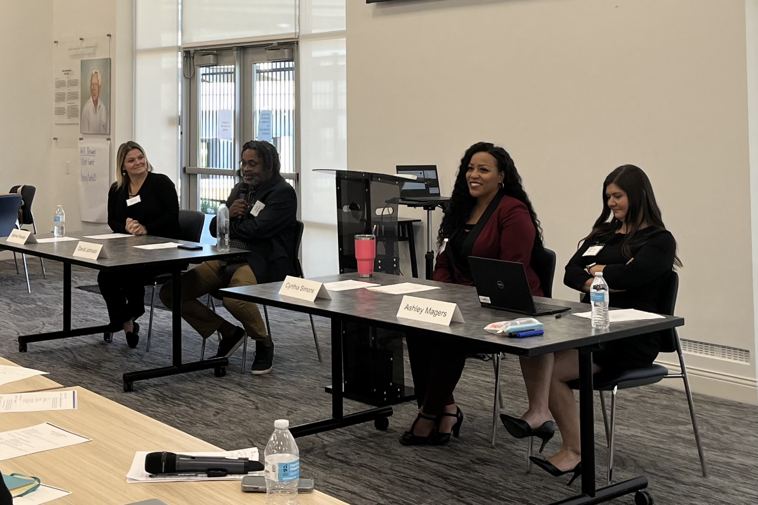 Four panelists seated at tables in front of a conference room during the Reentry Learning Collaborative that took place October 2024.