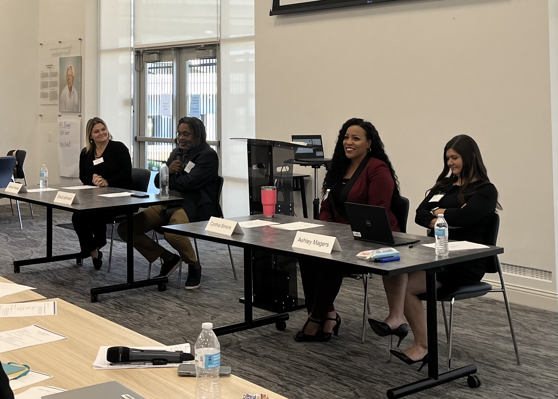 Four panelists seated at tables in front of a conference room during the Reentry Learning Collaborative that took place October 2024.