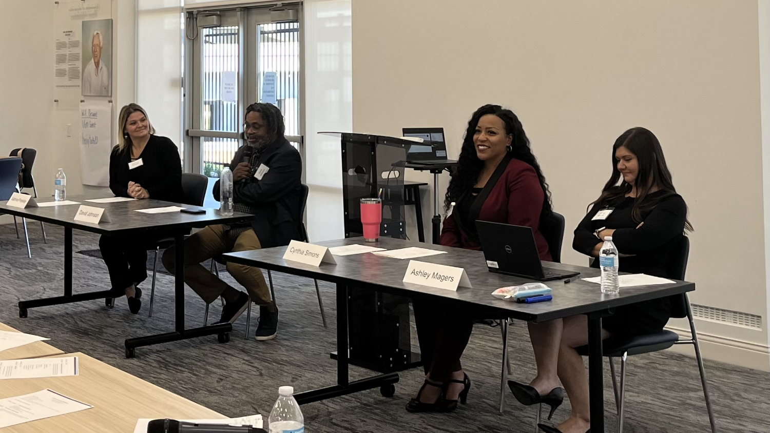 Four panelists seated at tables in front of a conference room during the Reentry Learning Collaborative that took place October 2024.