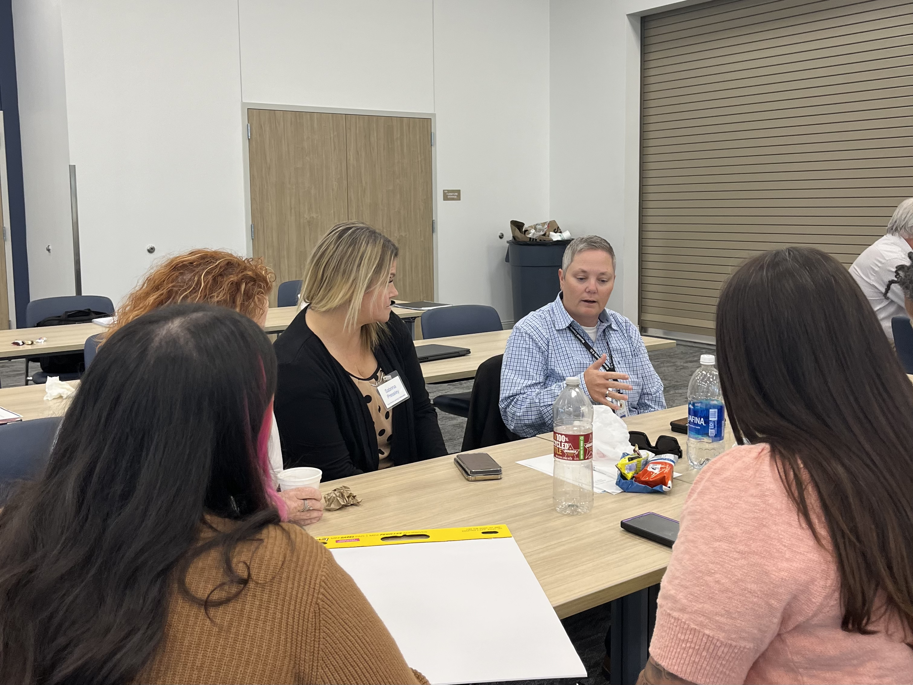 A group of people having a discussion at a table during the Reentry Learning Collaborative in October 2024.