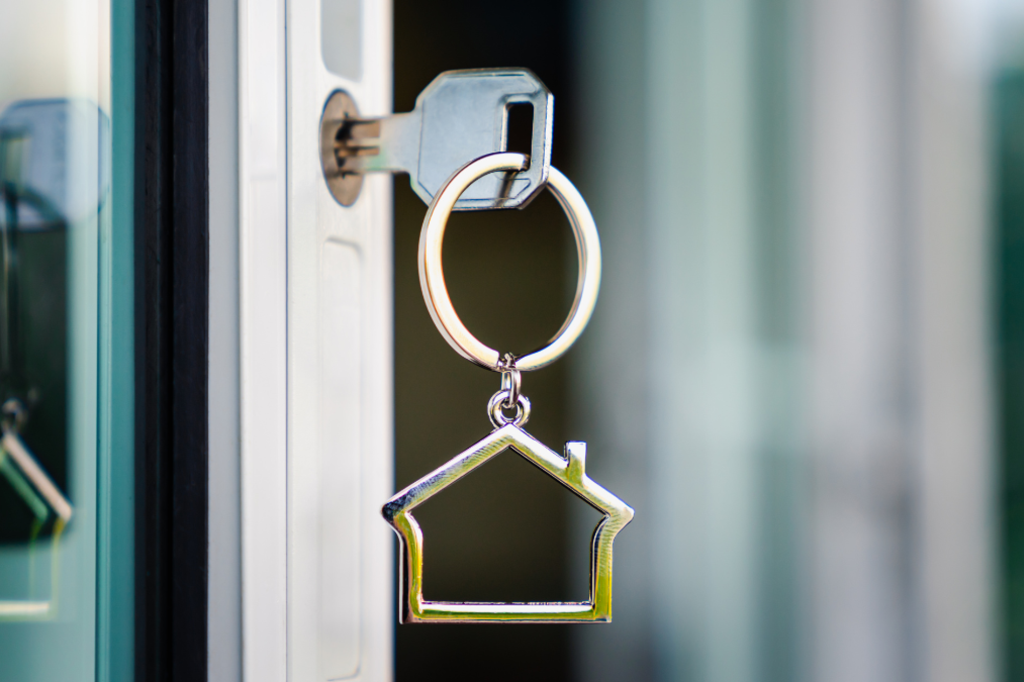 A key inserted into the keyhole of a front door.