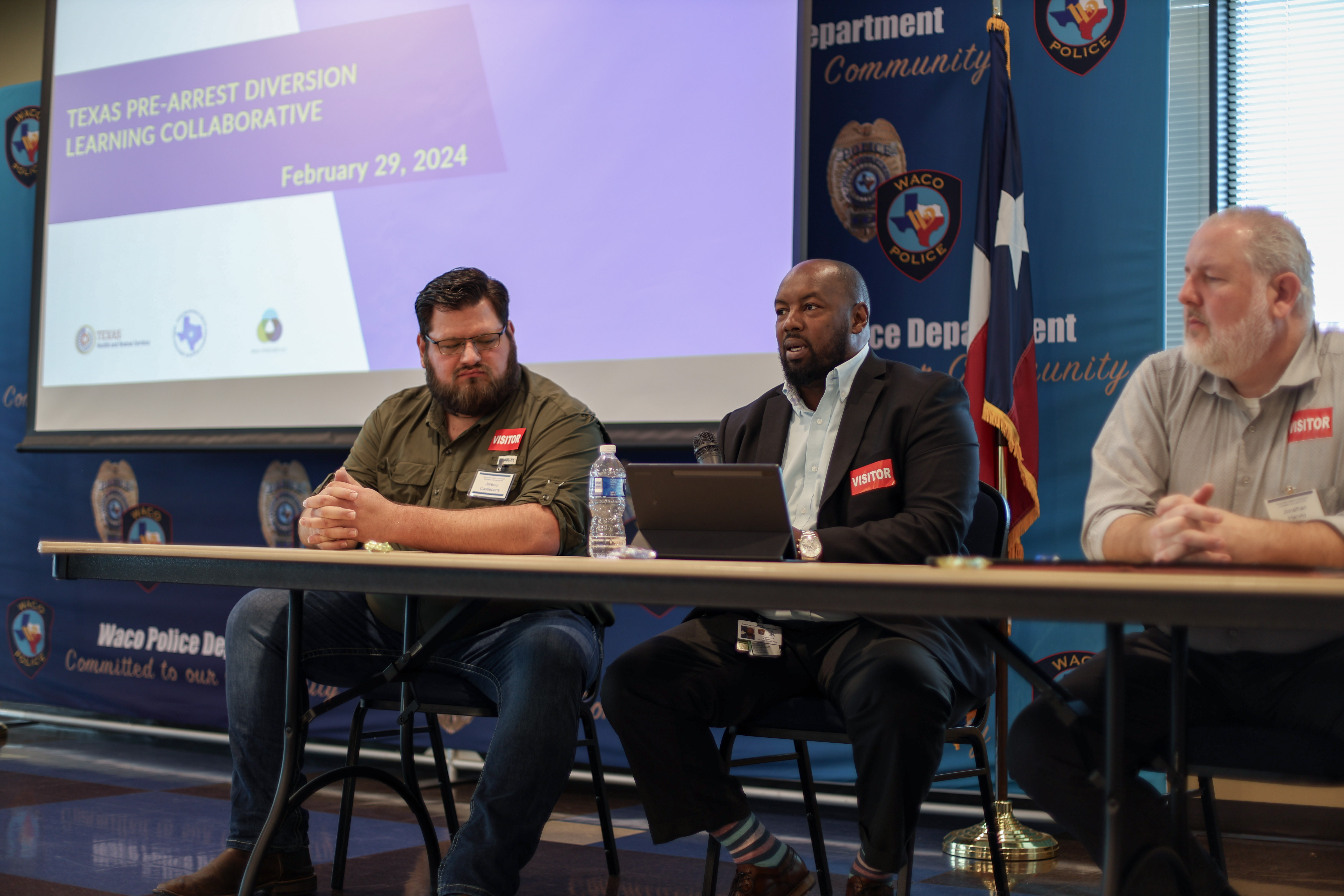 A panel of three male speakers at the Pre-Arrest Diversion Learning Collaborative meeting.